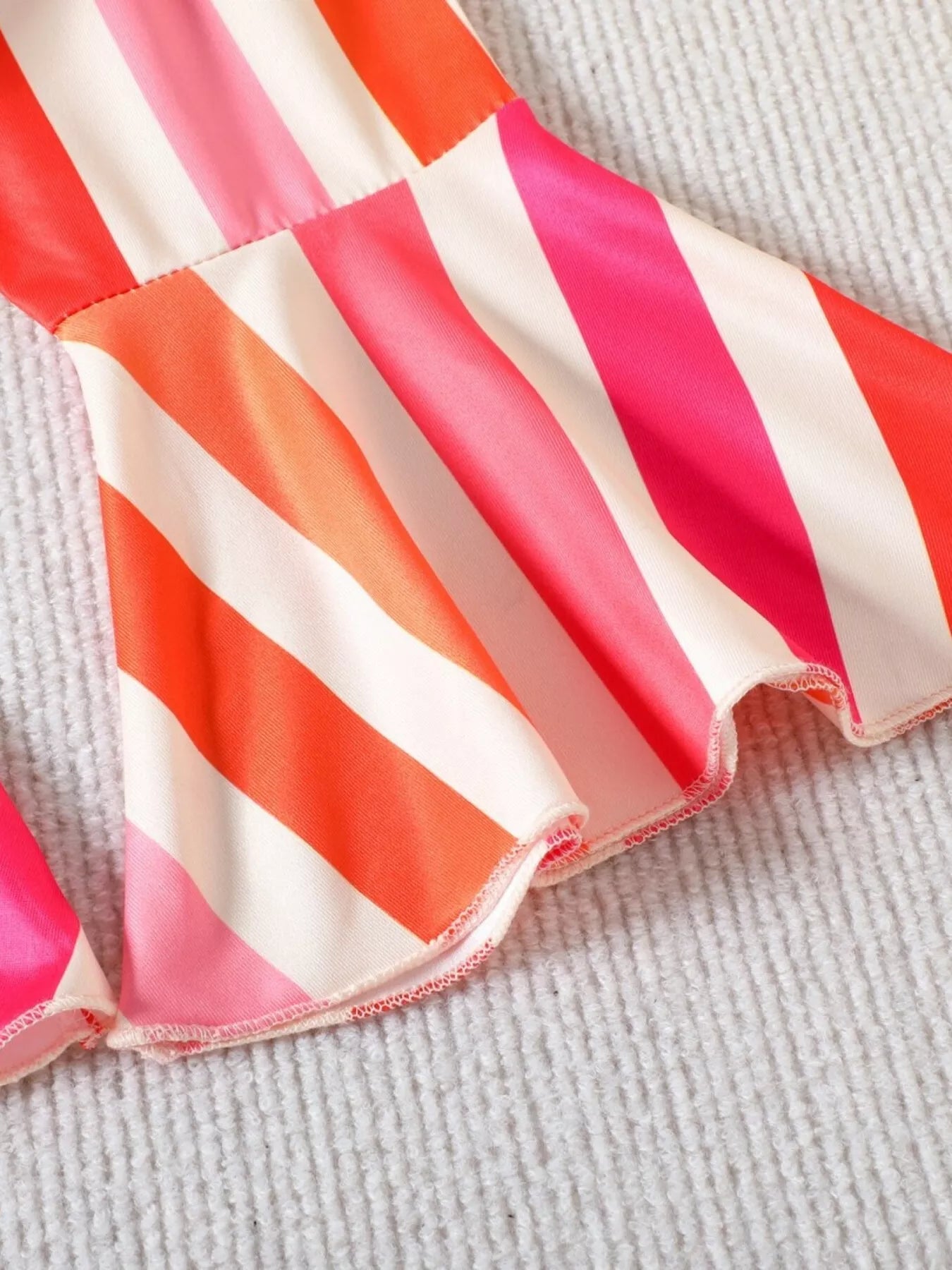 Girls two-piece beach outfit with floral halter-style top, striped flare pants, split hem detail, and soft cotton-blend fabric.