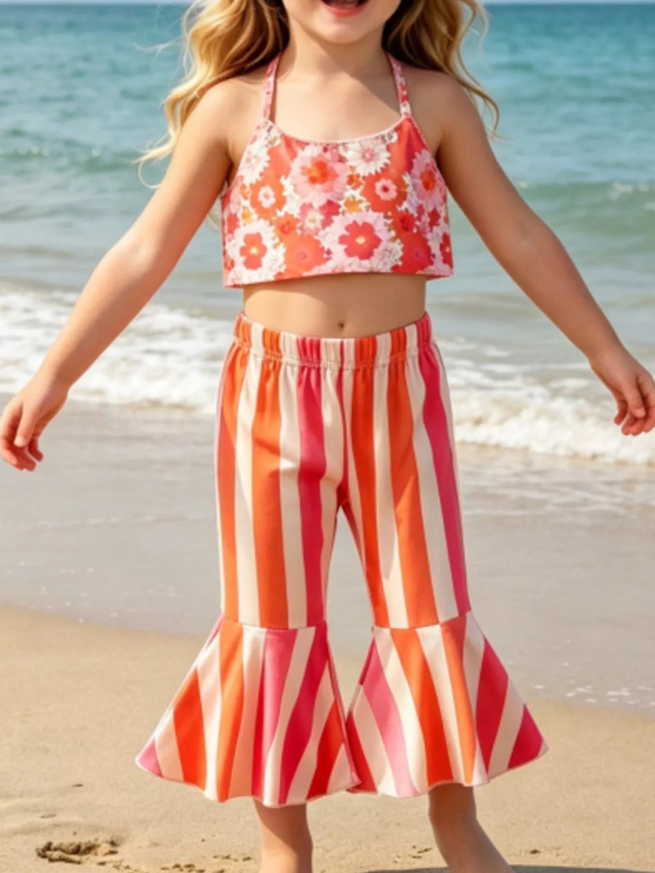 Girls two-piece beach outfit with floral halter-style top, striped flare pants, split hem detail, and soft cotton-blend fabric.