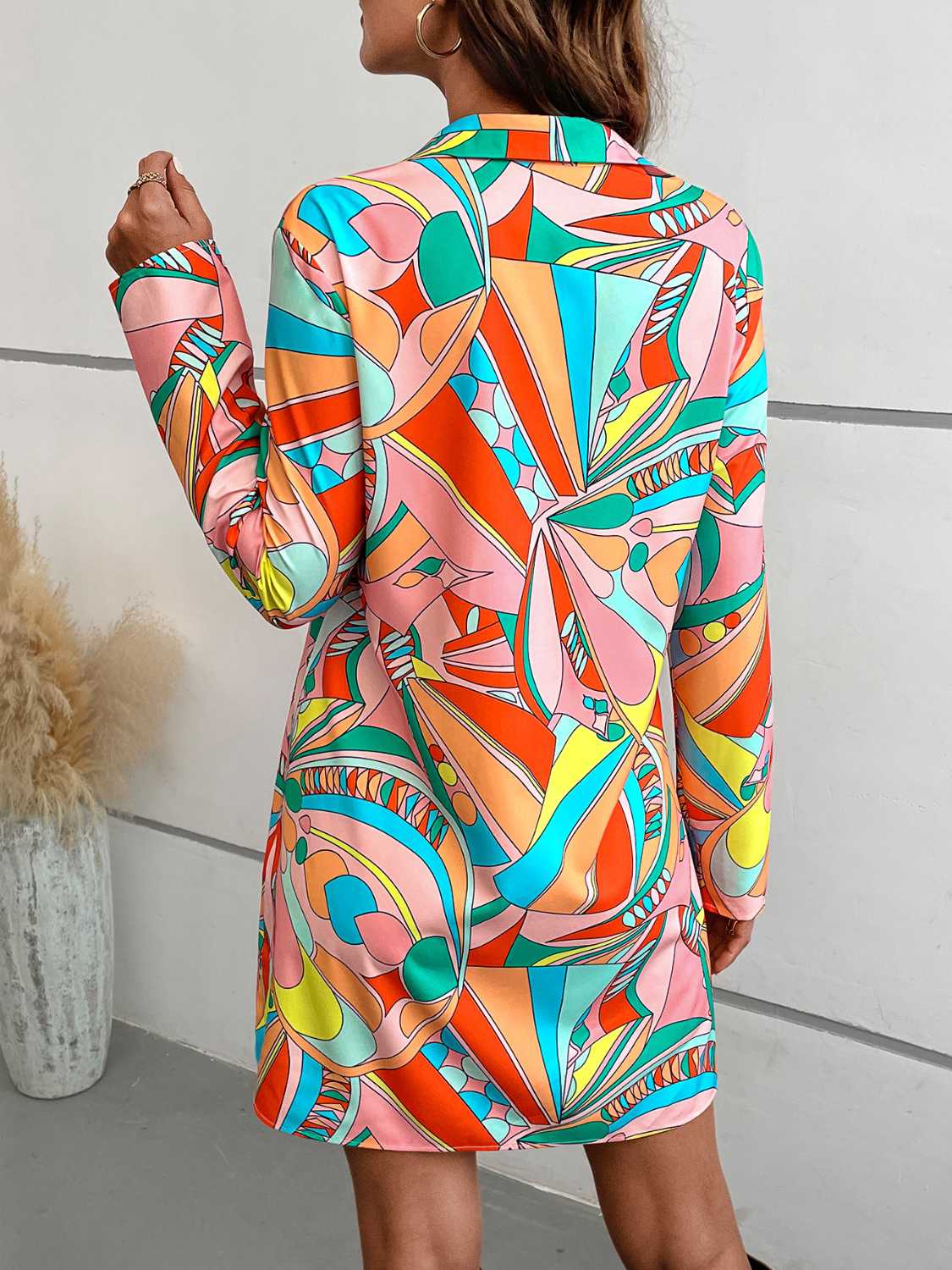 Model wearing Sherbet Swirl Shirt Dress in colorful abstract sherbert-inspired print with long sleeves and button-down front.
