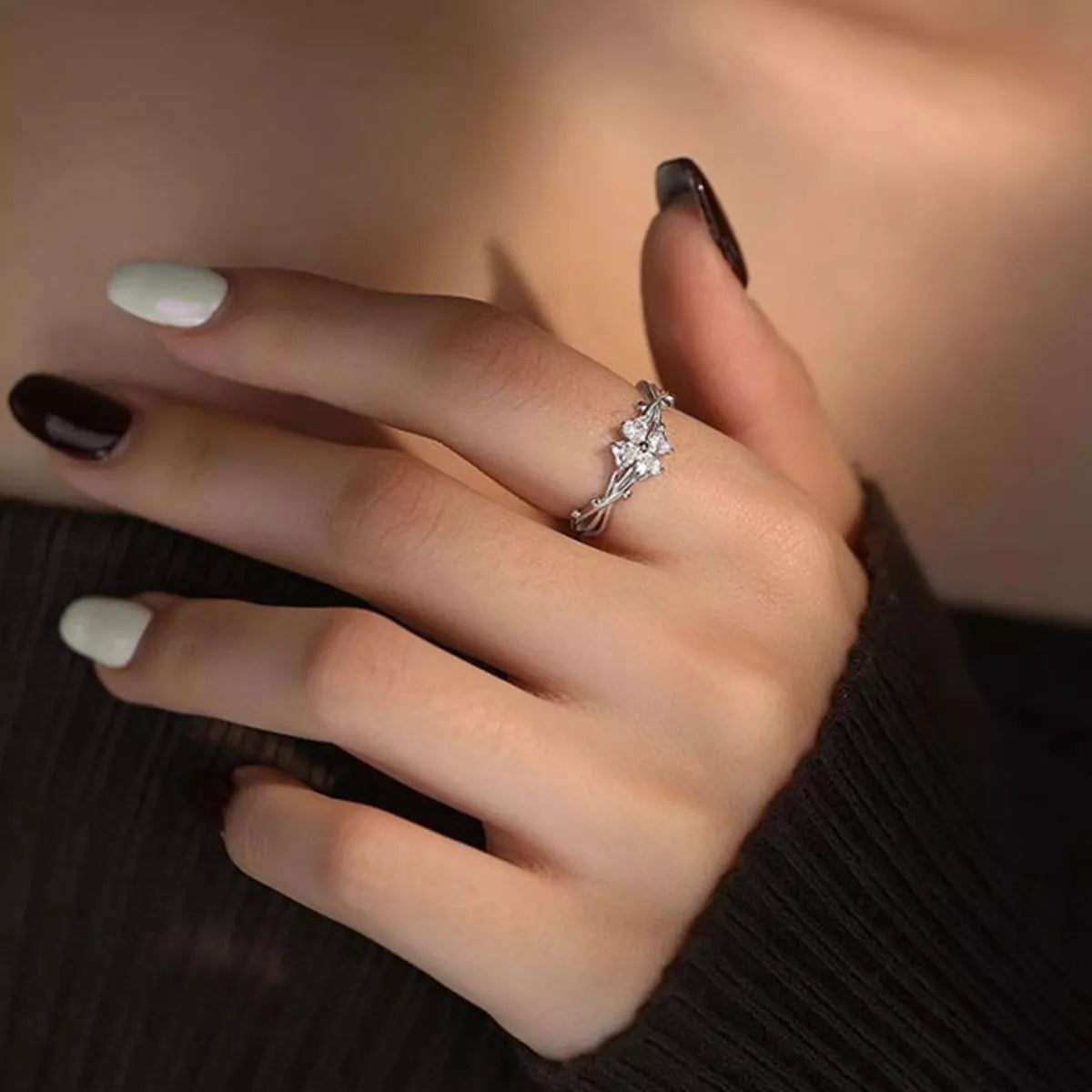 Adjustable 925 sterling silver floral branch ring with sparkling zircon flower accents worn on a finger.
