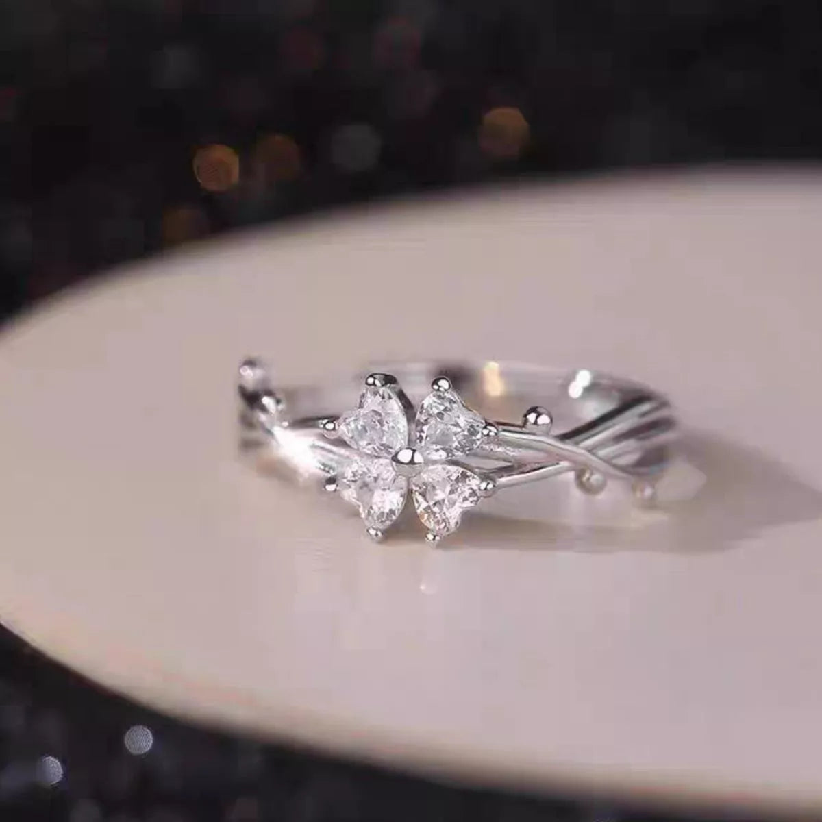 Adjustable 925 sterling silver floral branch ring with sparkling zircon flower accents worn on a finger.
