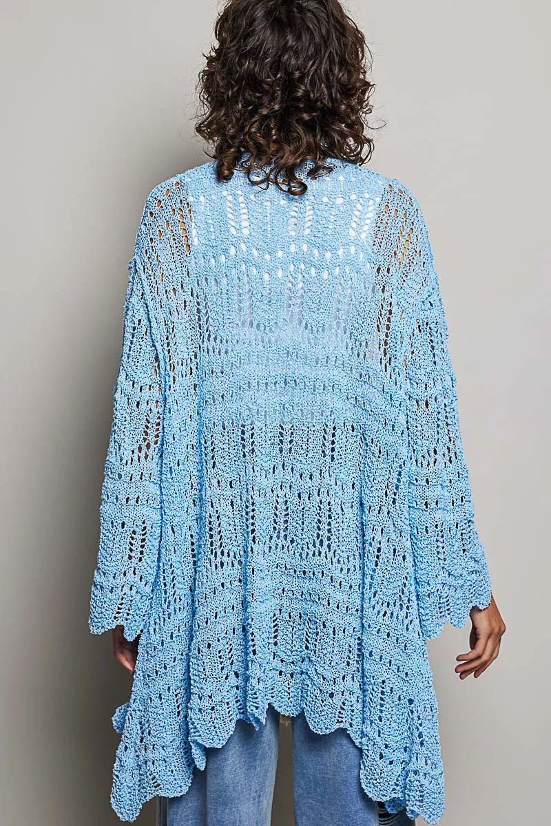 Woman wearing a lightweight openwork blue cardigan over a white tank and jeans