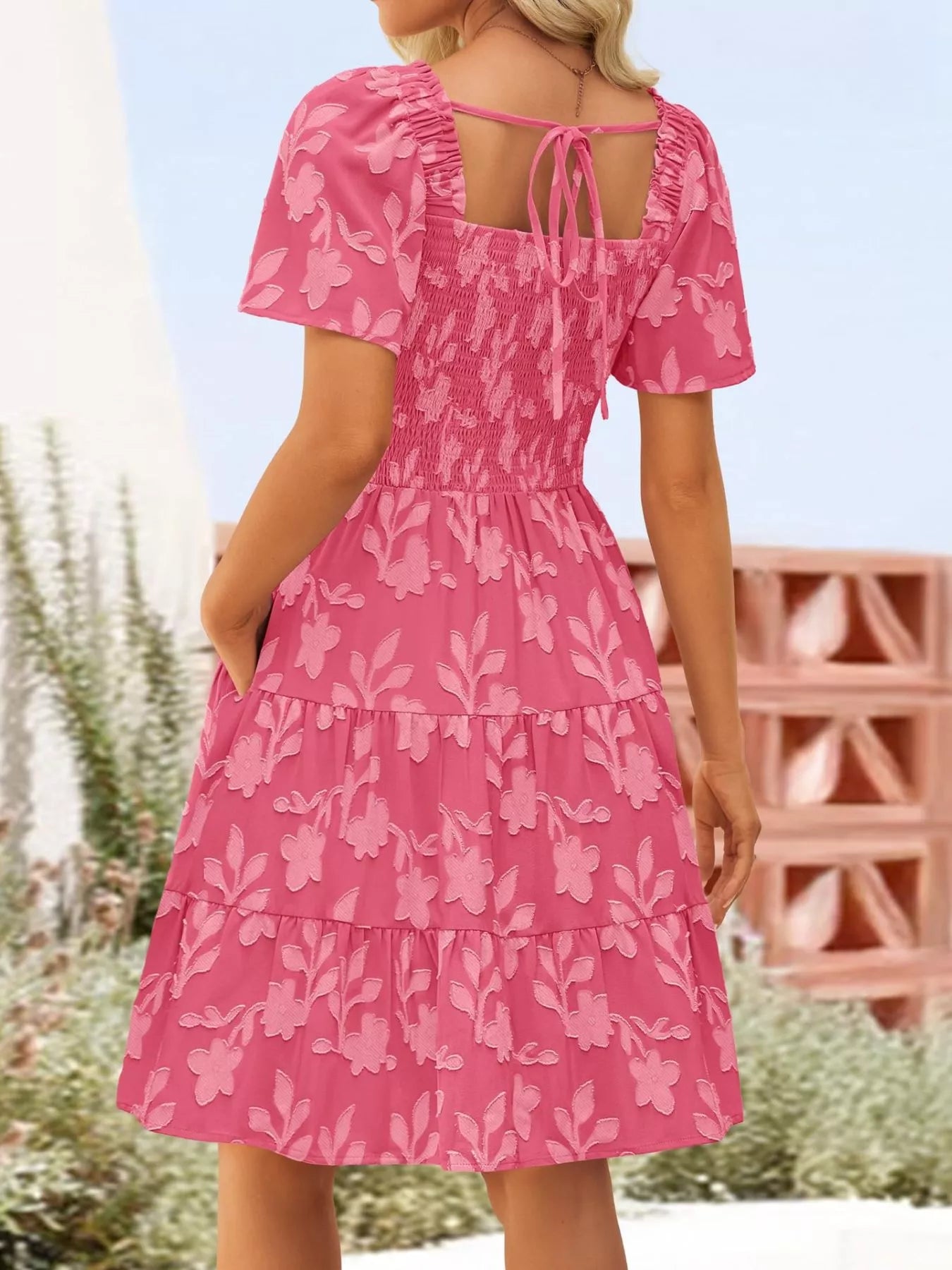 Tiered dress with smocked bodice, flutter sleeves, and textured floral fabric