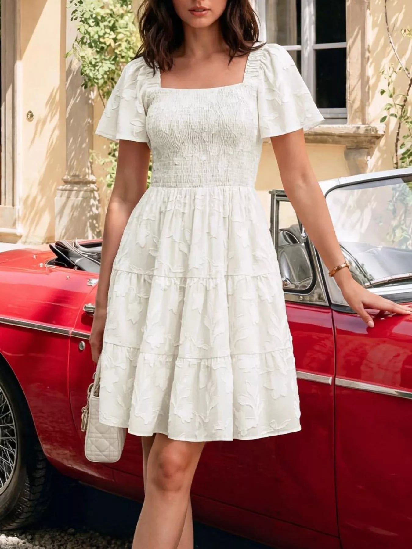 Tiered dress with smocked bodice, flutter sleeves, and textured floral fabric