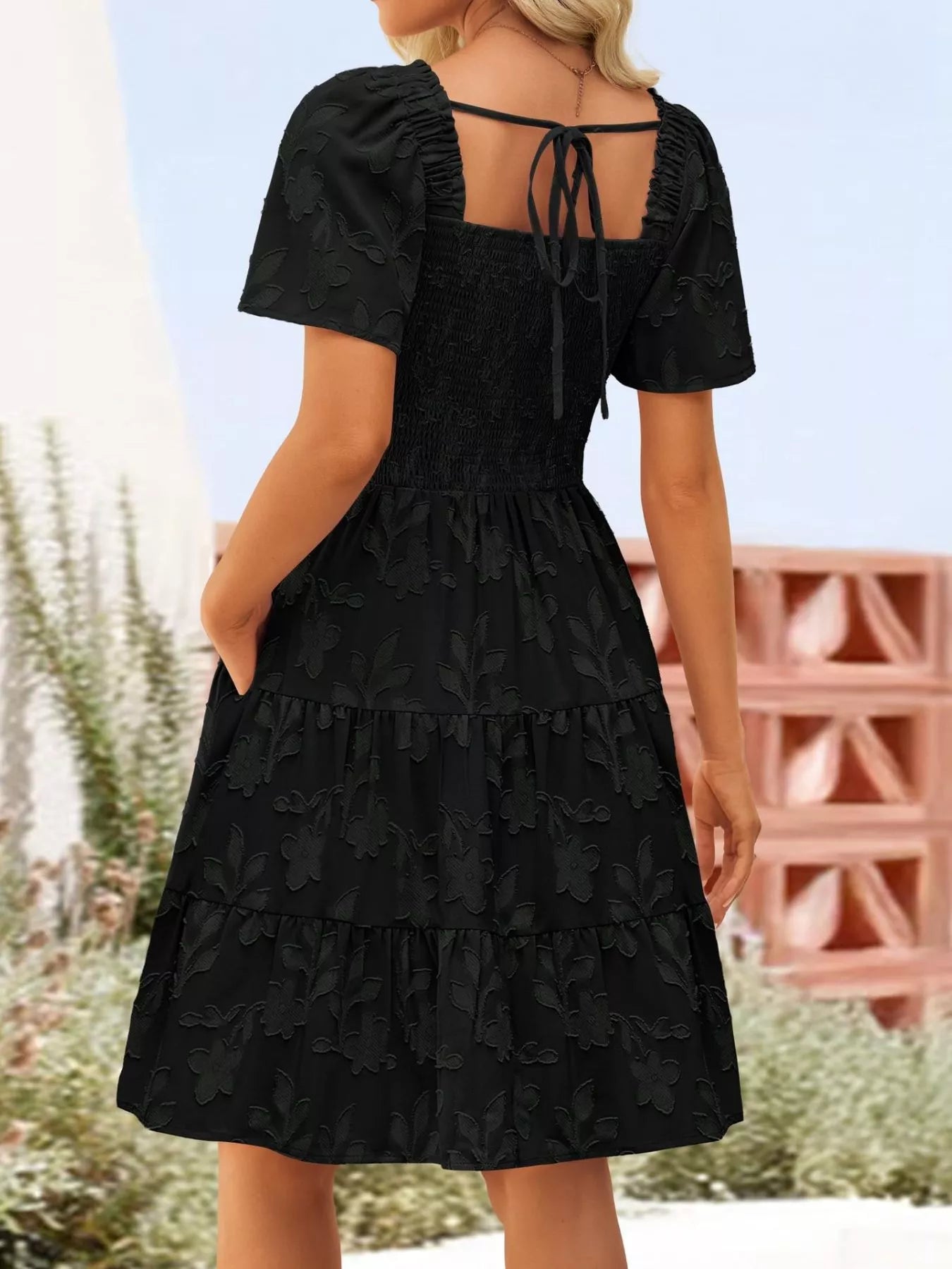 Tiered dress with smocked bodice, flutter sleeves, and textured floral fabric