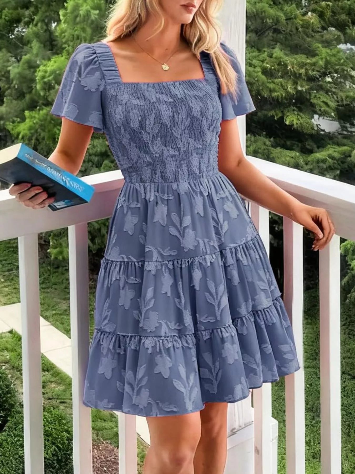 Tiered dress with smocked bodice, flutter sleeves, and textured floral fabric