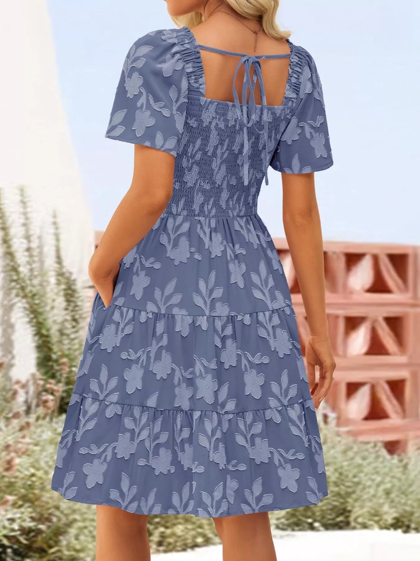 Tiered dress with smocked bodice, flutter sleeves, and textured floral fabric