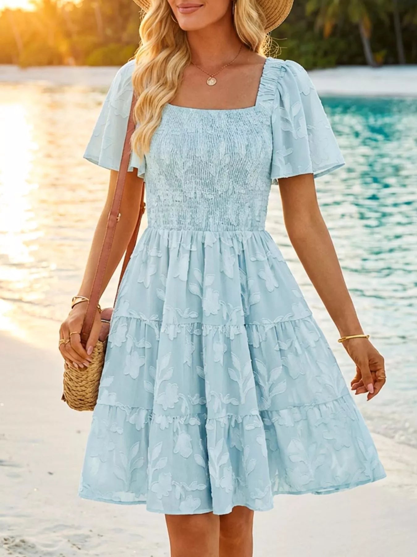 Tiered dress with smocked bodice, flutter sleeves, and textured floral fabric