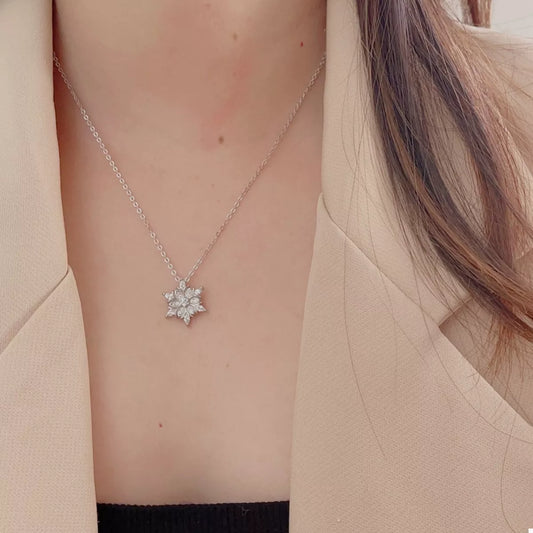 Close-up of the Snow Blossom Pendant Necklace featuring a platinum-plated 925 sterling silver chain and a zircon snowflake-inspired floral pendant, photographed against a neutral background.