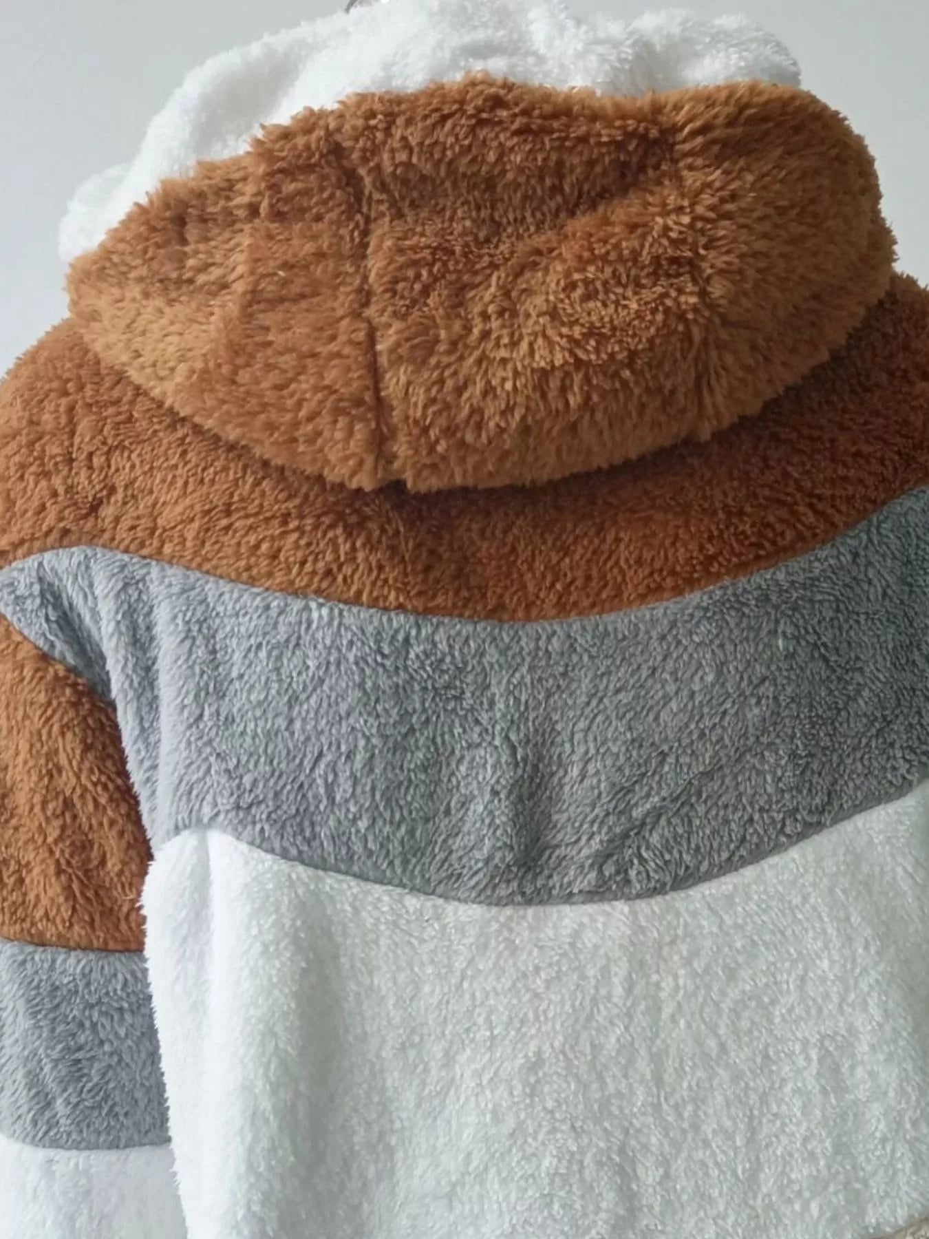 Soft plush faux fur zip jacket with drawstring hood and pockets.