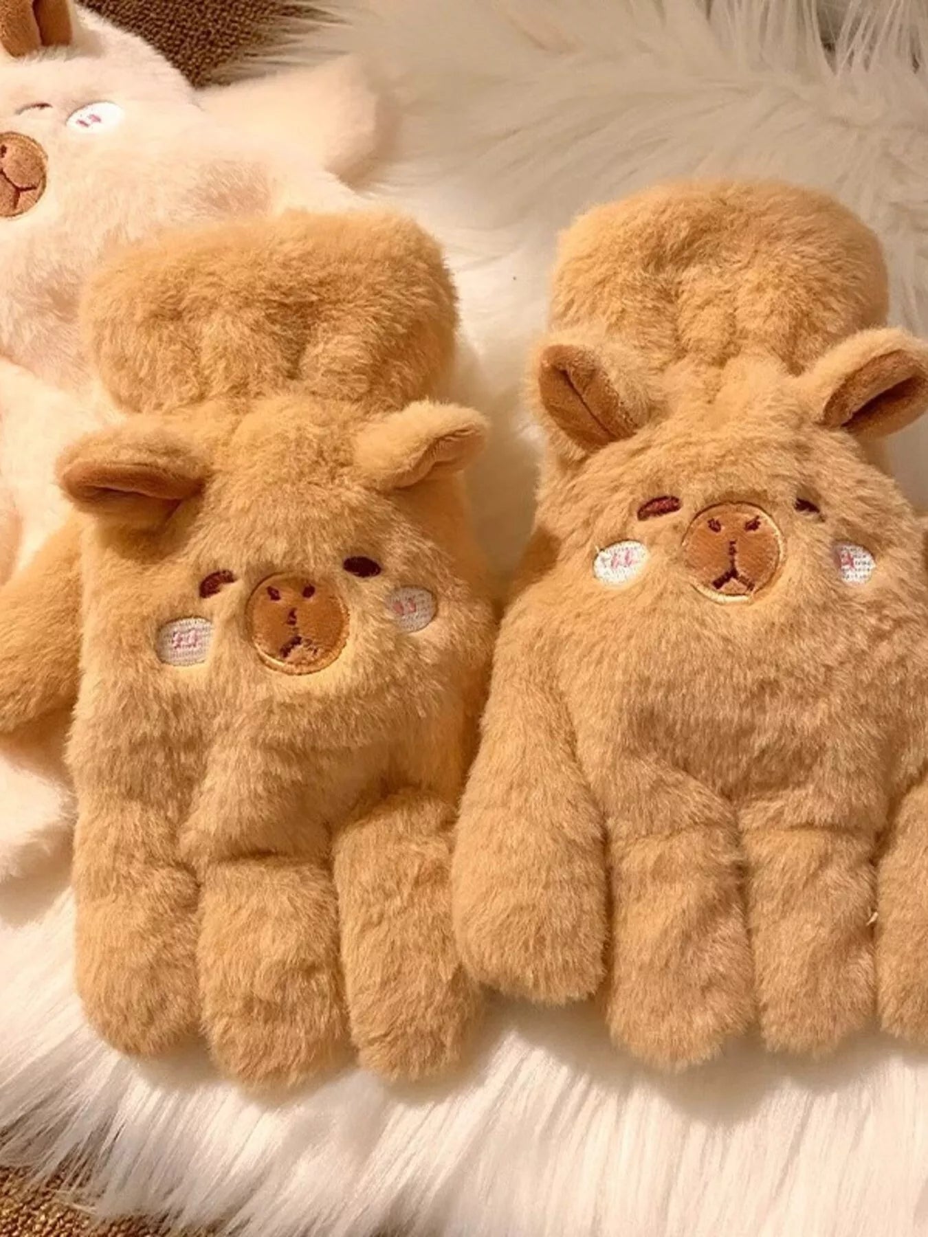 Pair of fluffy lamb-shaped plush gloves in soft neutral tones, cozy and cute winter handwear