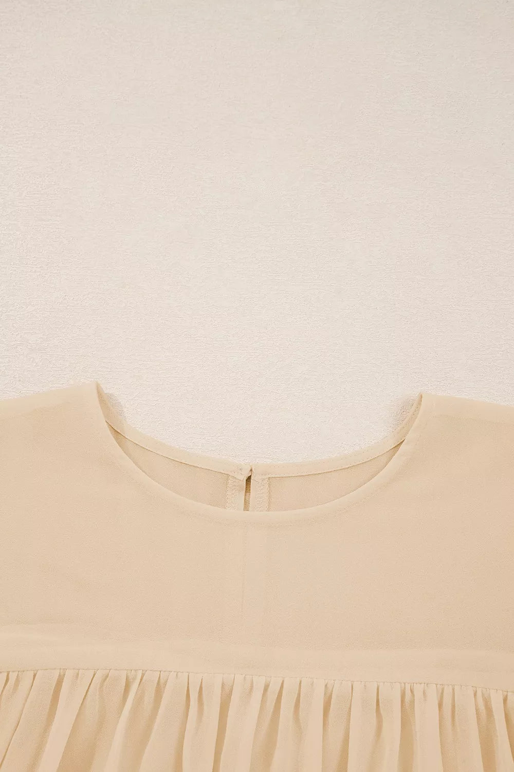 Flowy ruffle sleeve blouse with a relaxed silhouette styled with jeans and a casual coffee cup.