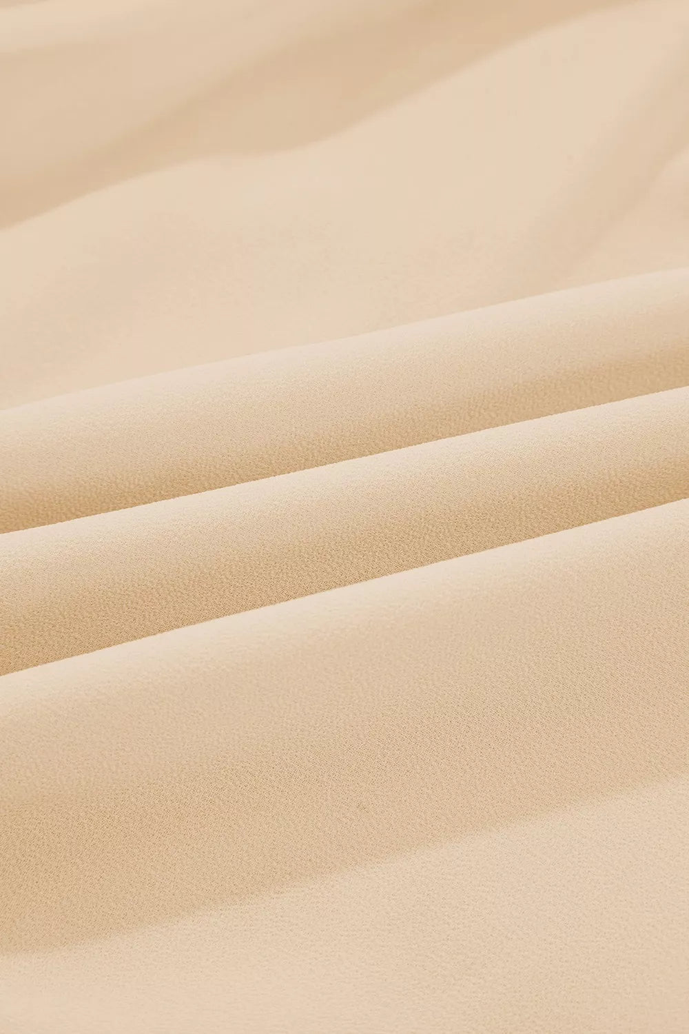 Flowy ruffle sleeve blouse with a relaxed silhouette styled with jeans and a casual coffee cup.