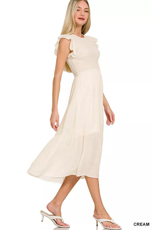 Cream smocked midi dress with ruffle sleeves and tiered skirt on model