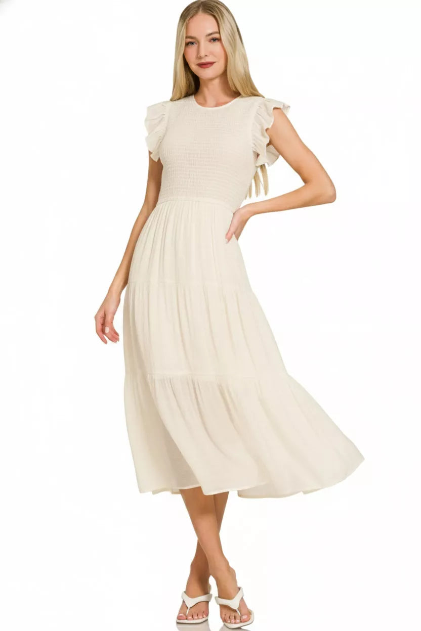 Cream smocked midi dress with ruffle sleeves and tiered skirt on model