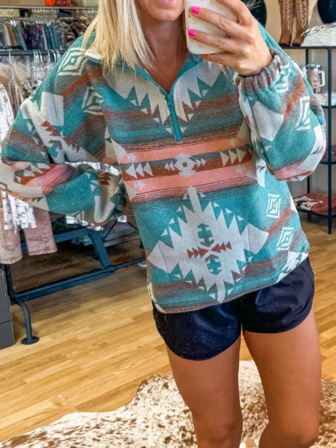 Turquoise Aztec print quarter zip sweatshirt with elastic cuffs.