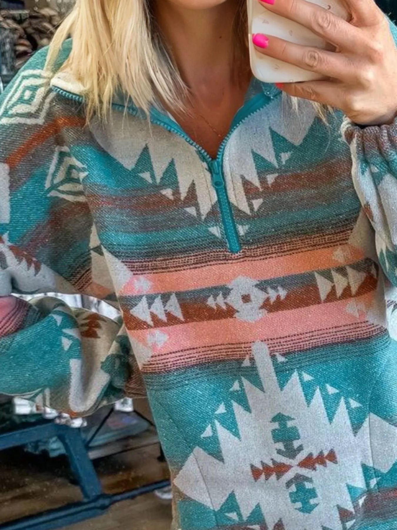 Turquoise Aztec print quarter zip sweatshirt with elastic cuffs.