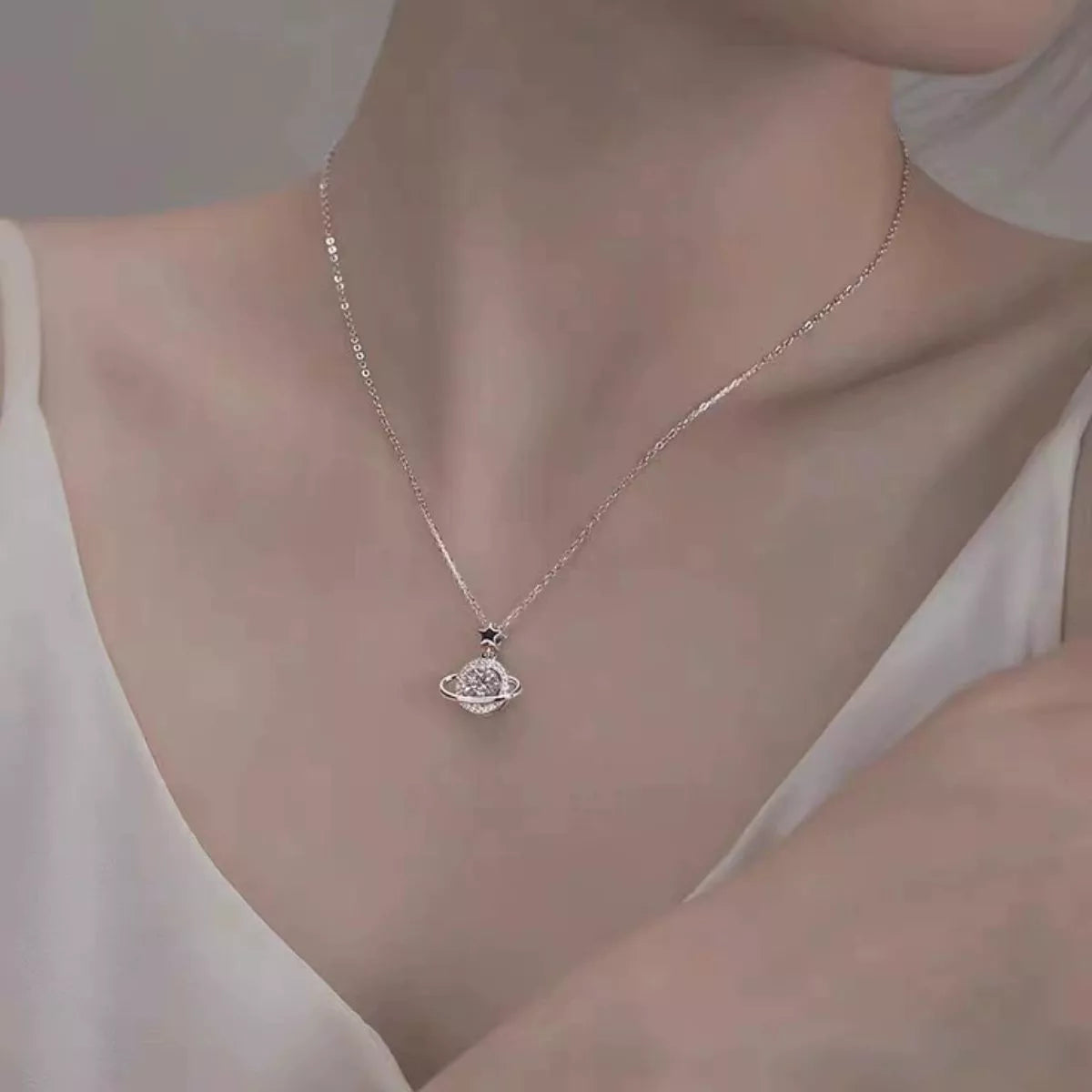 Sterling silver Saturn-inspired pendant necklace with 1ct moissanite center stone, star accent, and matching jewelry box.