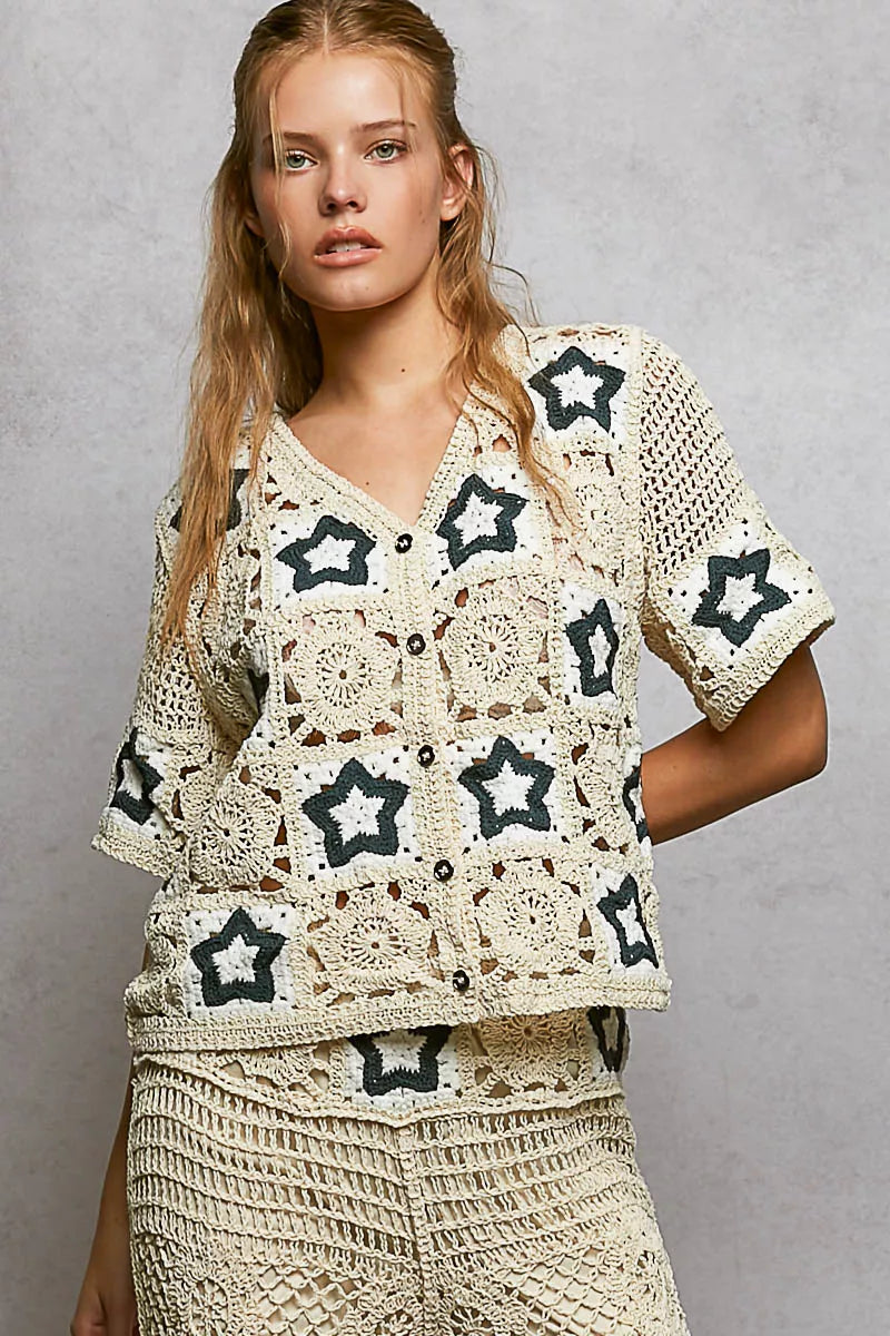 Cream crochet button-front cardigan featuring openwork detailing and contrast star motifs in a relaxed boho silhouette