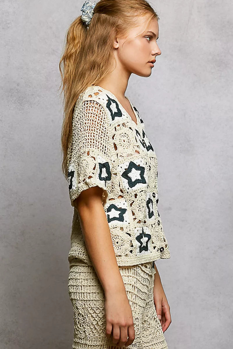 Cream crochet button-front cardigan featuring openwork detailing and contrast star motifs in a relaxed boho silhouette