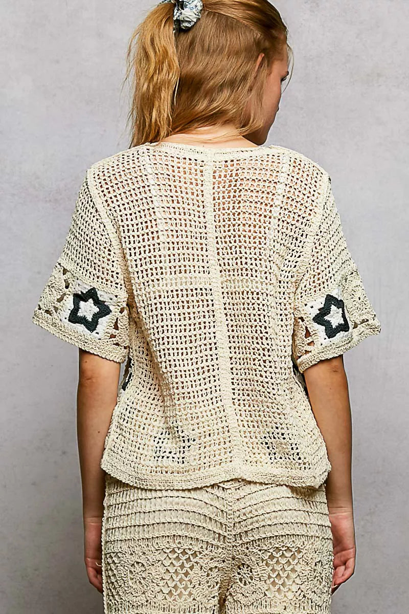 Cream crochet button-front cardigan featuring openwork detailing and contrast star motifs in a relaxed boho silhouette