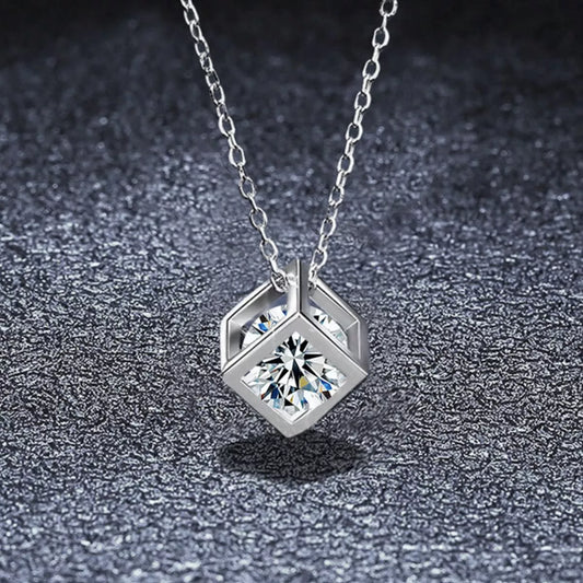 Platinum plated sterling silver geometric pendant necklace featuring a sparkling moissanite stone on a dark textured background