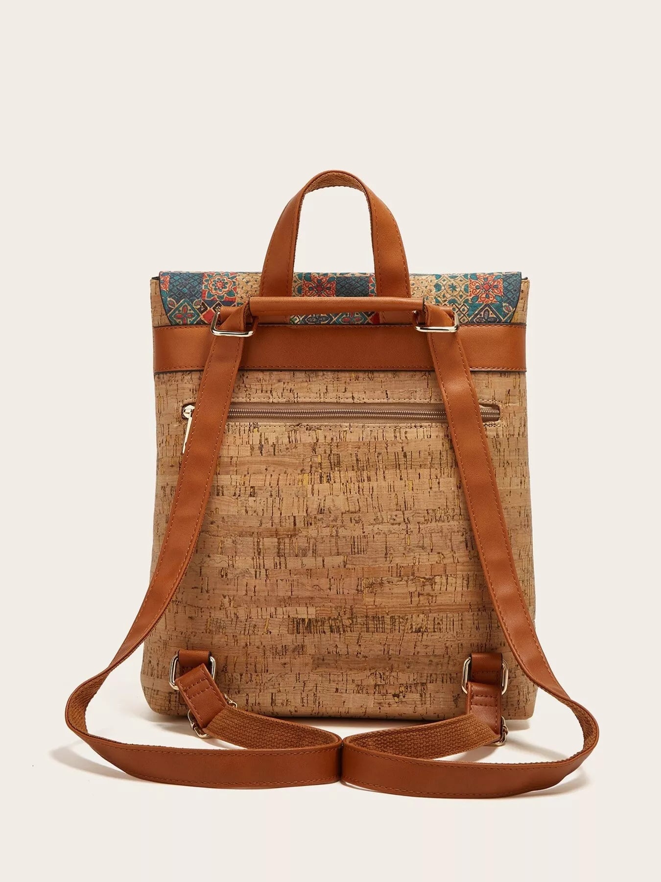 Cork backpack with brown leather straps on a beige background