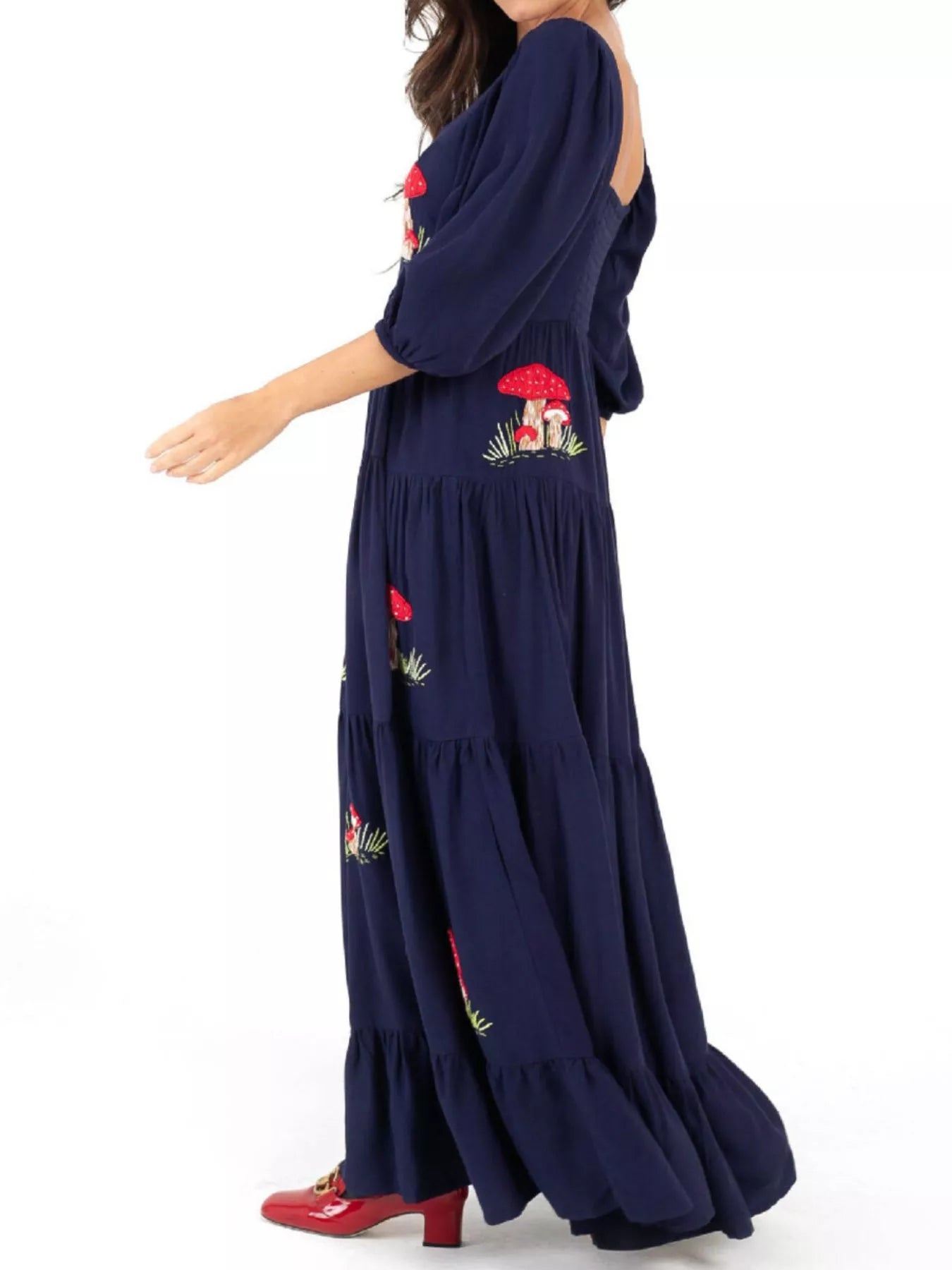 Woman wearing navy maxi dress with red mushroom embroidery and square neckline