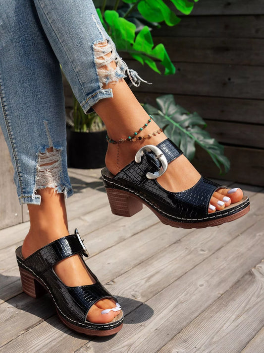 Black crocodile-textured open toe block heel sandals with bold buckle.