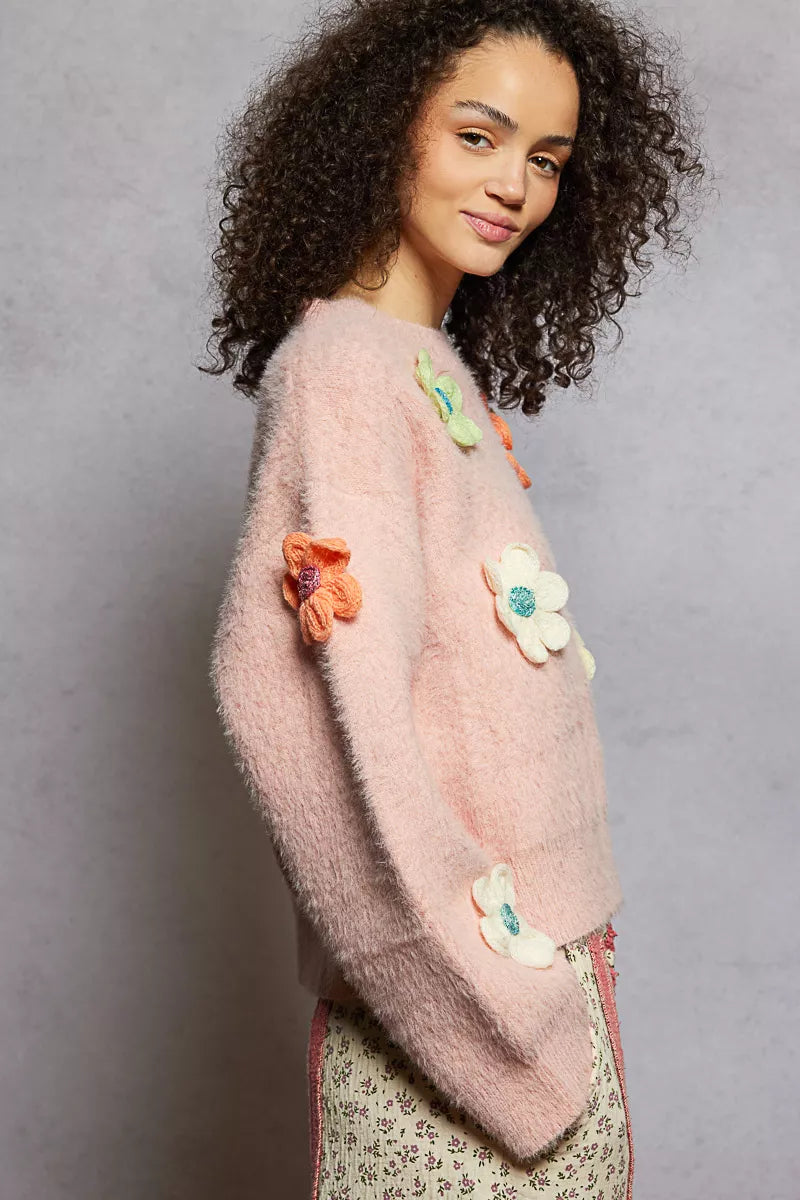 Model wearing the Sugar Blossom Mohair Sweater — a soft pink fuzzy knit with colorful 3D floral appliqués, paired with floral skirt.