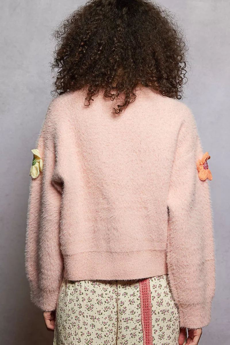 Model wearing the Sugar Blossom Mohair Sweater — a soft pink fuzzy knit with colorful 3D floral appliqués, paired with floral skirt.