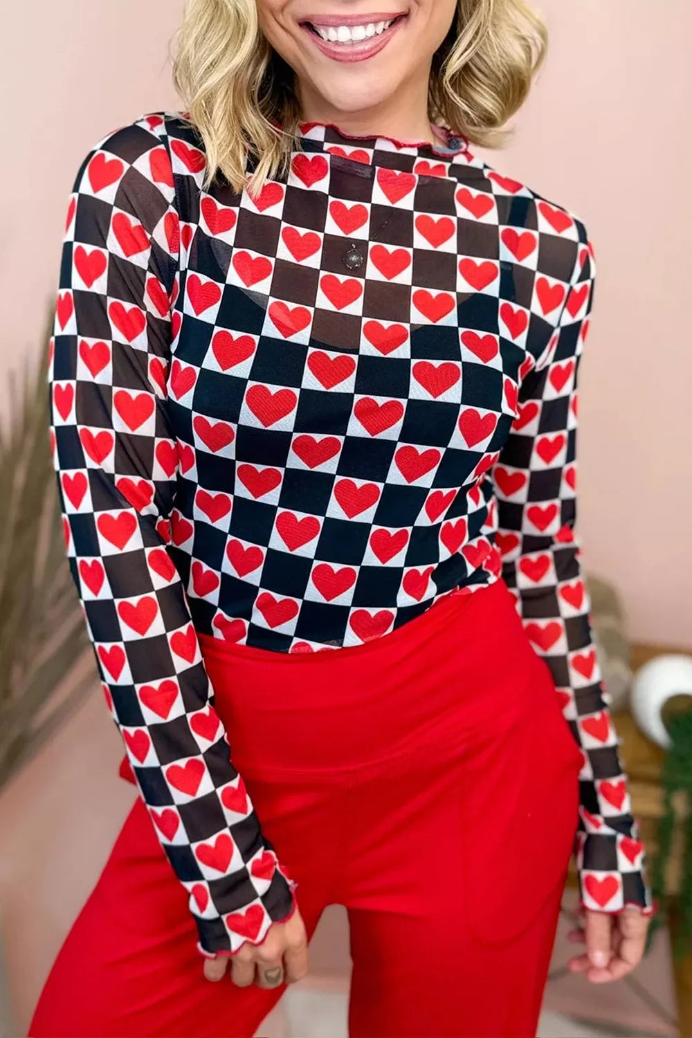 Bright pink and red checkered sheer mesh long sleeve top with a slightly stretchy fit styled with light denim jeans.