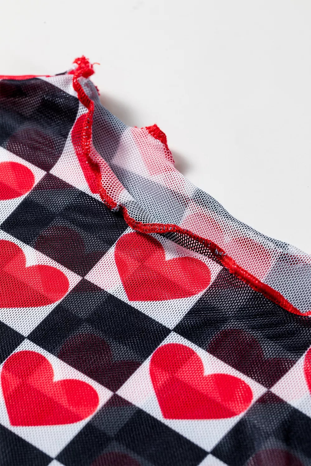 Bright pink and red checkered sheer mesh long sleeve top with a slightly stretchy fit styled with light denim jeans.