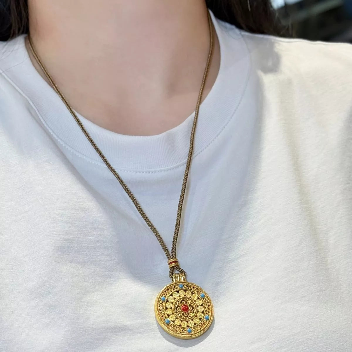 18K gold-plated medallion necklace with ornate circular design, zircon accents, and colorful red and turquoise details.