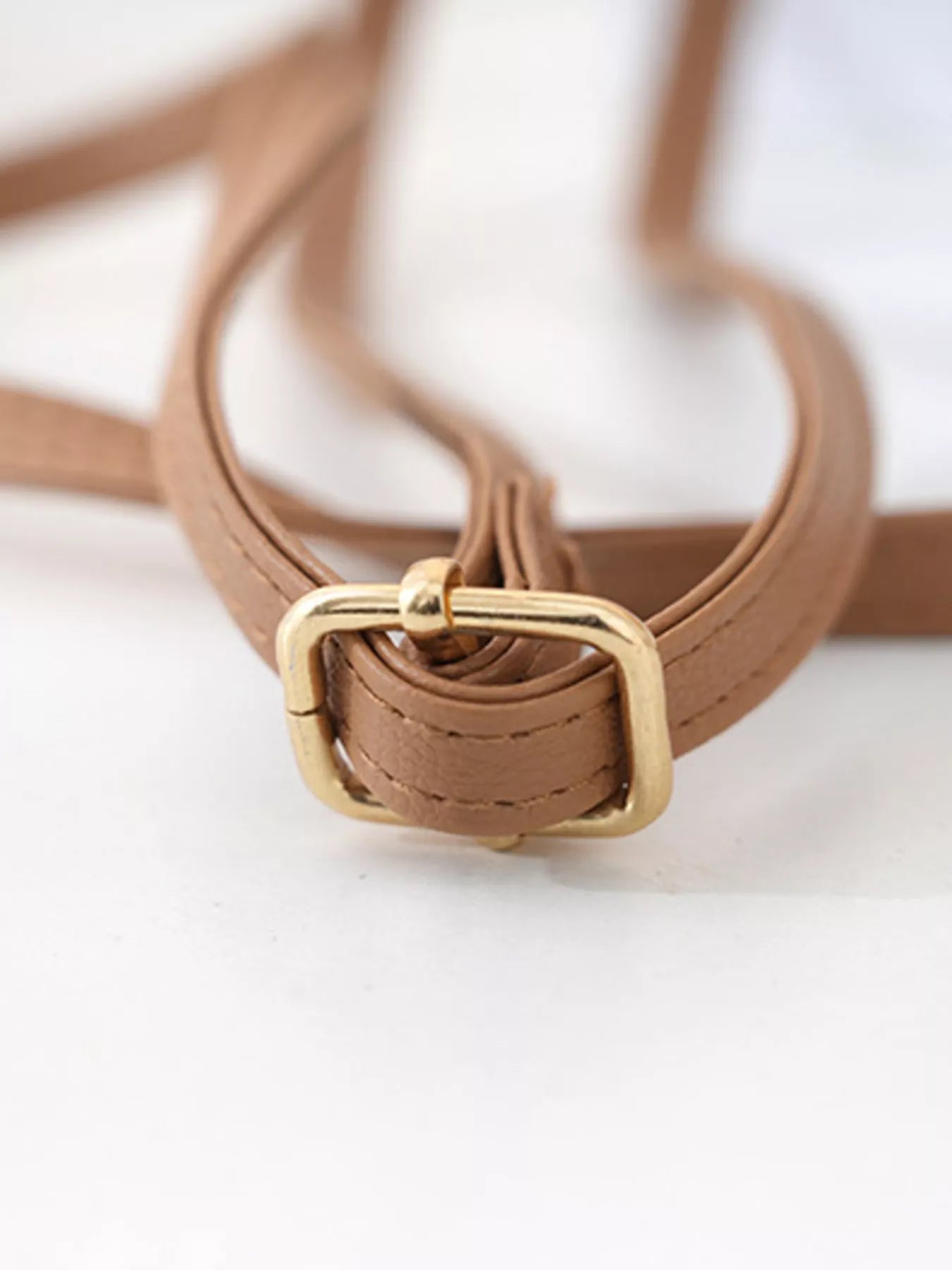 Small round crochet crossbody bag in natural beige cotton thread with scalloped edges and a flap closure.