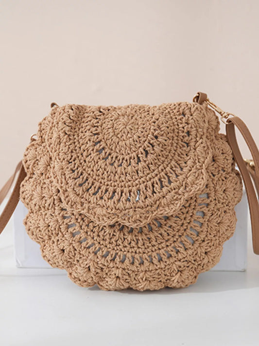 Small round crochet crossbody bag in natural beige cotton thread with scalloped edges and a flap closure.