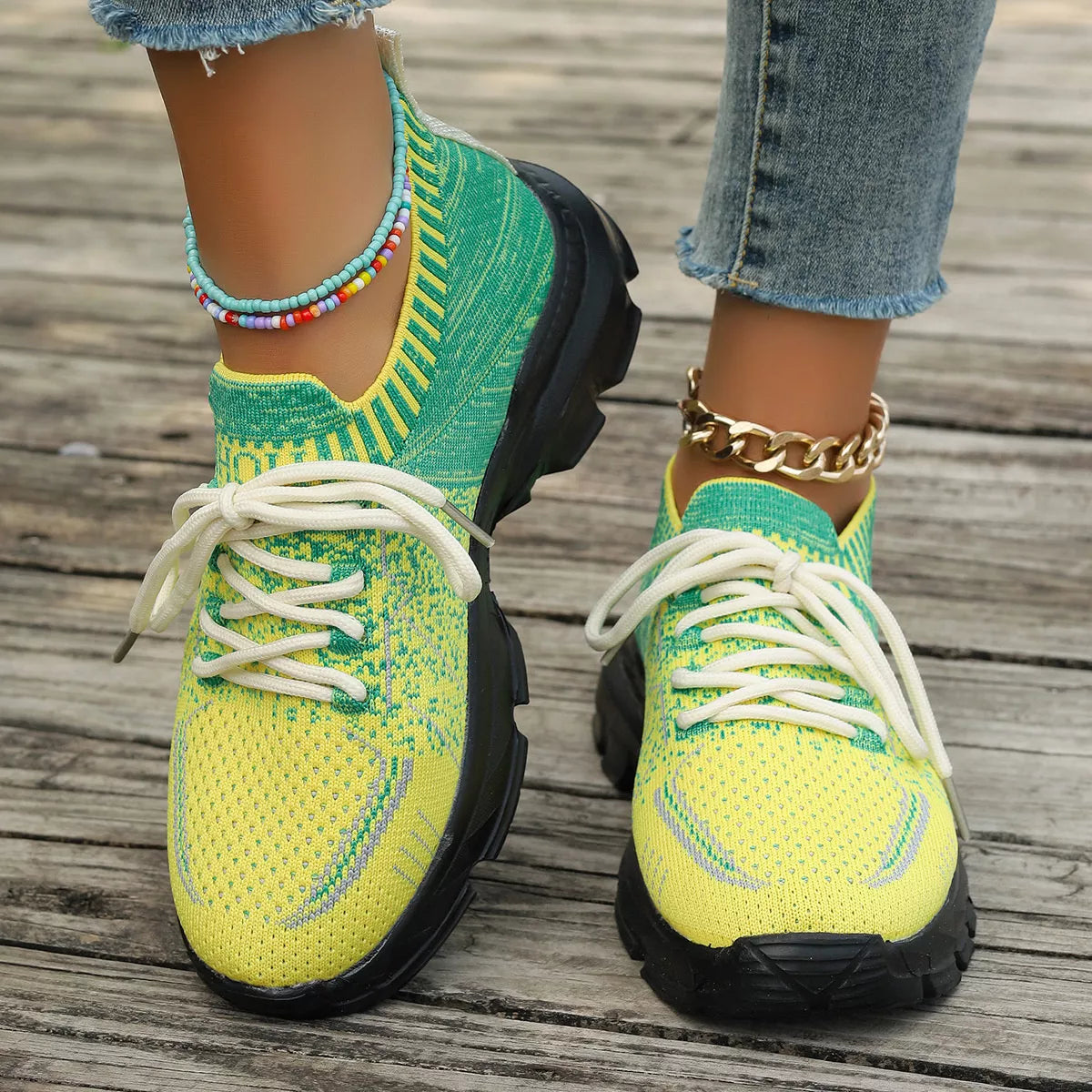 Bright yellow and green knit mesh sneakers with white laces, black rubber soles, and a flat sporty design.