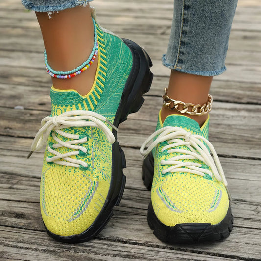 Bright yellow and green knit mesh sneakers with white laces, black rubber soles, and a flat sporty design.