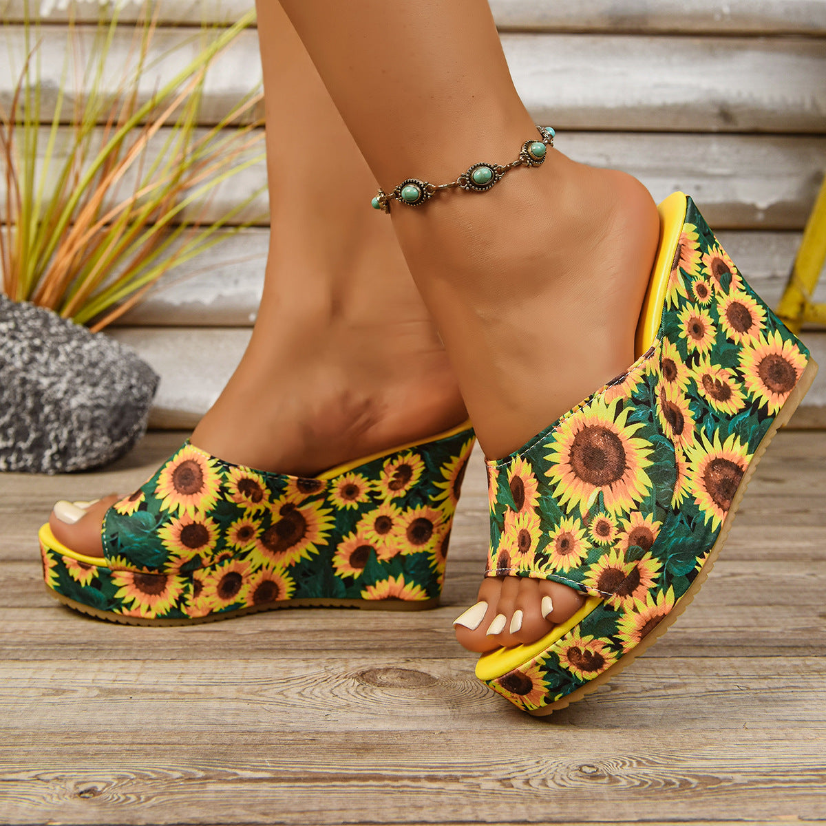 Woman wearing sunflower print wedge sandals with floral embellishment