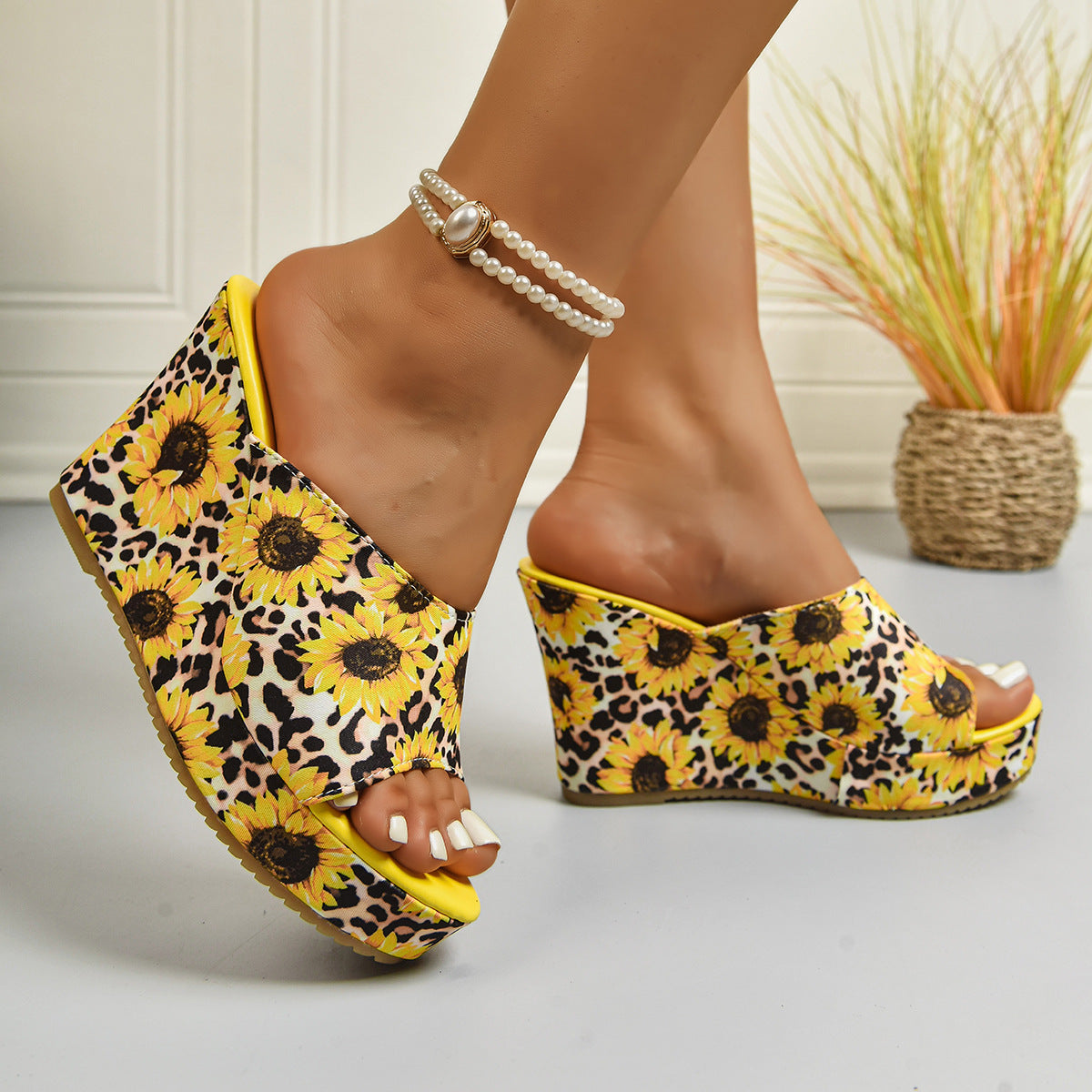 Woman wearing sunflower print wedge sandals with floral embellishment