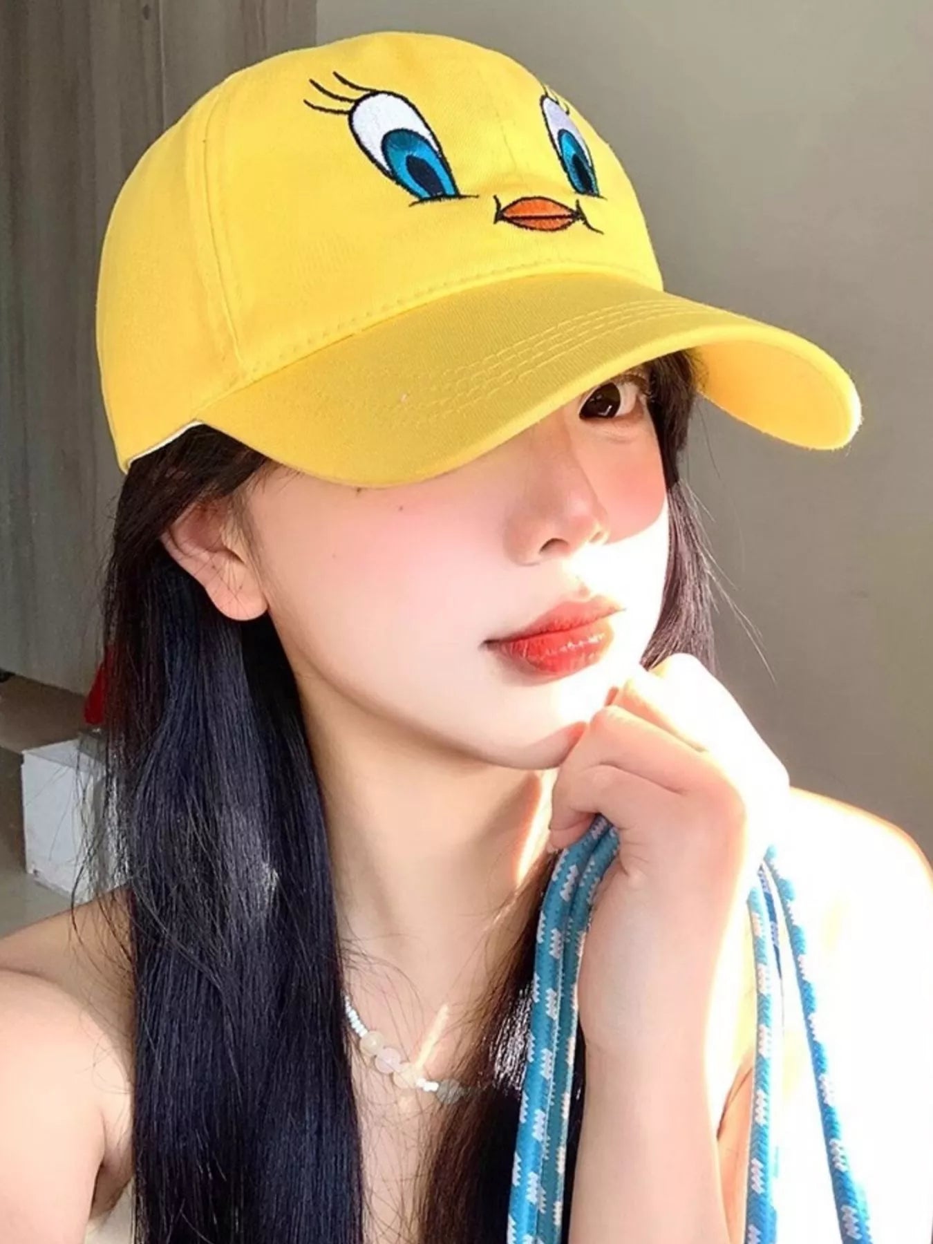 Bright yellow cotton baseball cap with an embroidered bird face design on the front.
