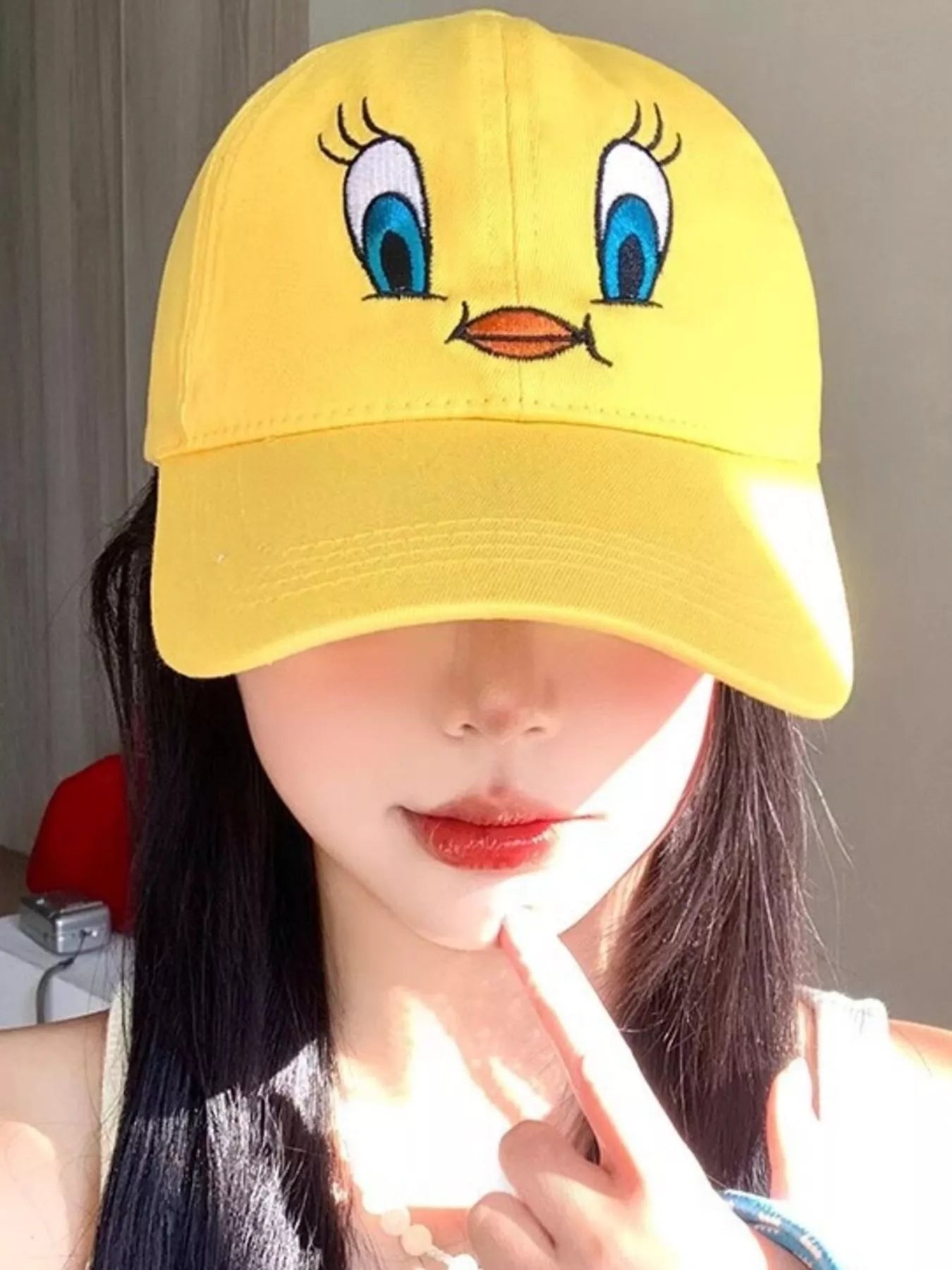 Bright yellow cotton baseball cap with an embroidered bird face design on the front.