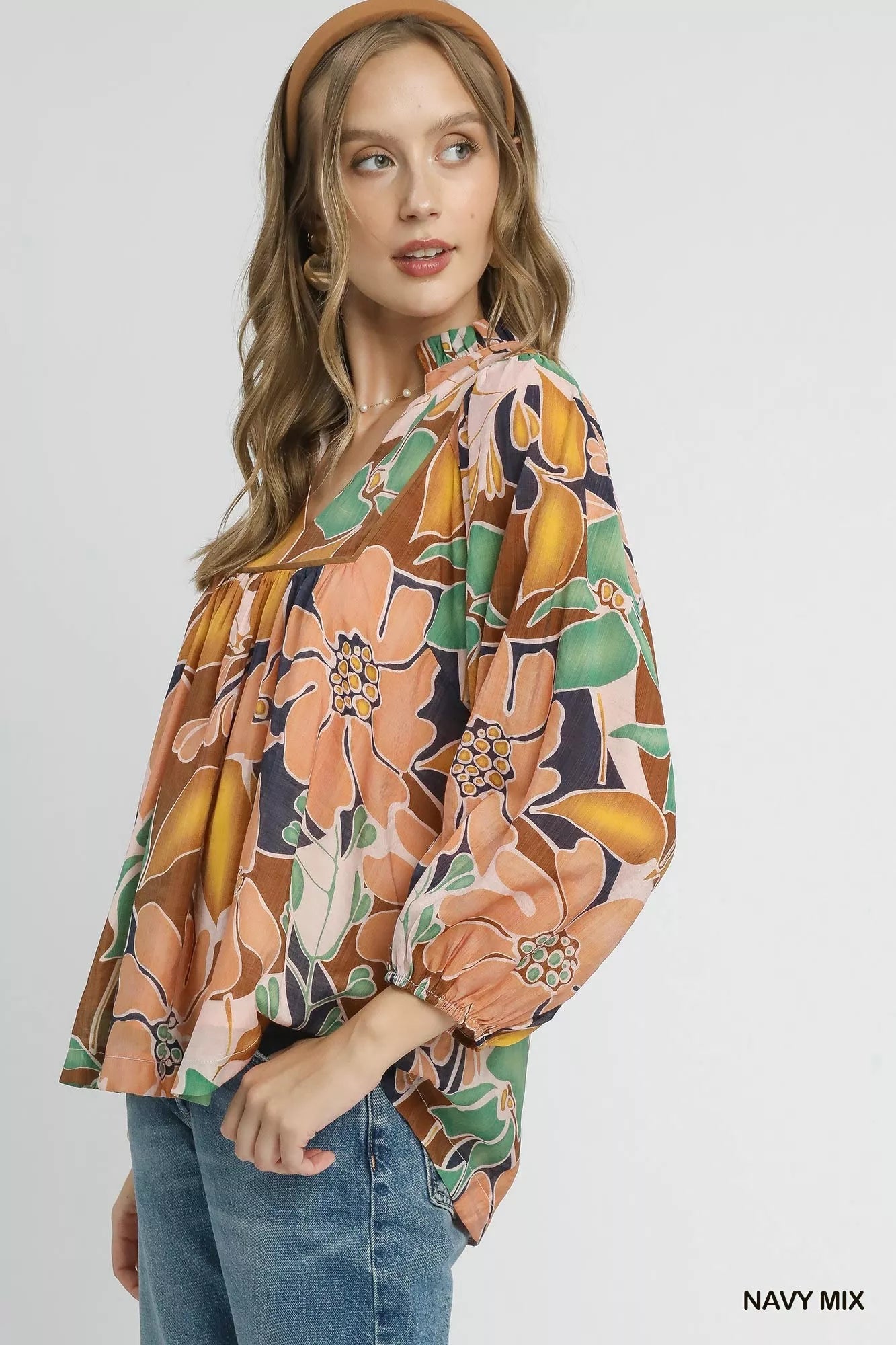 Multicolor abstract floral print blouse with ruffle neck and long sleeves.