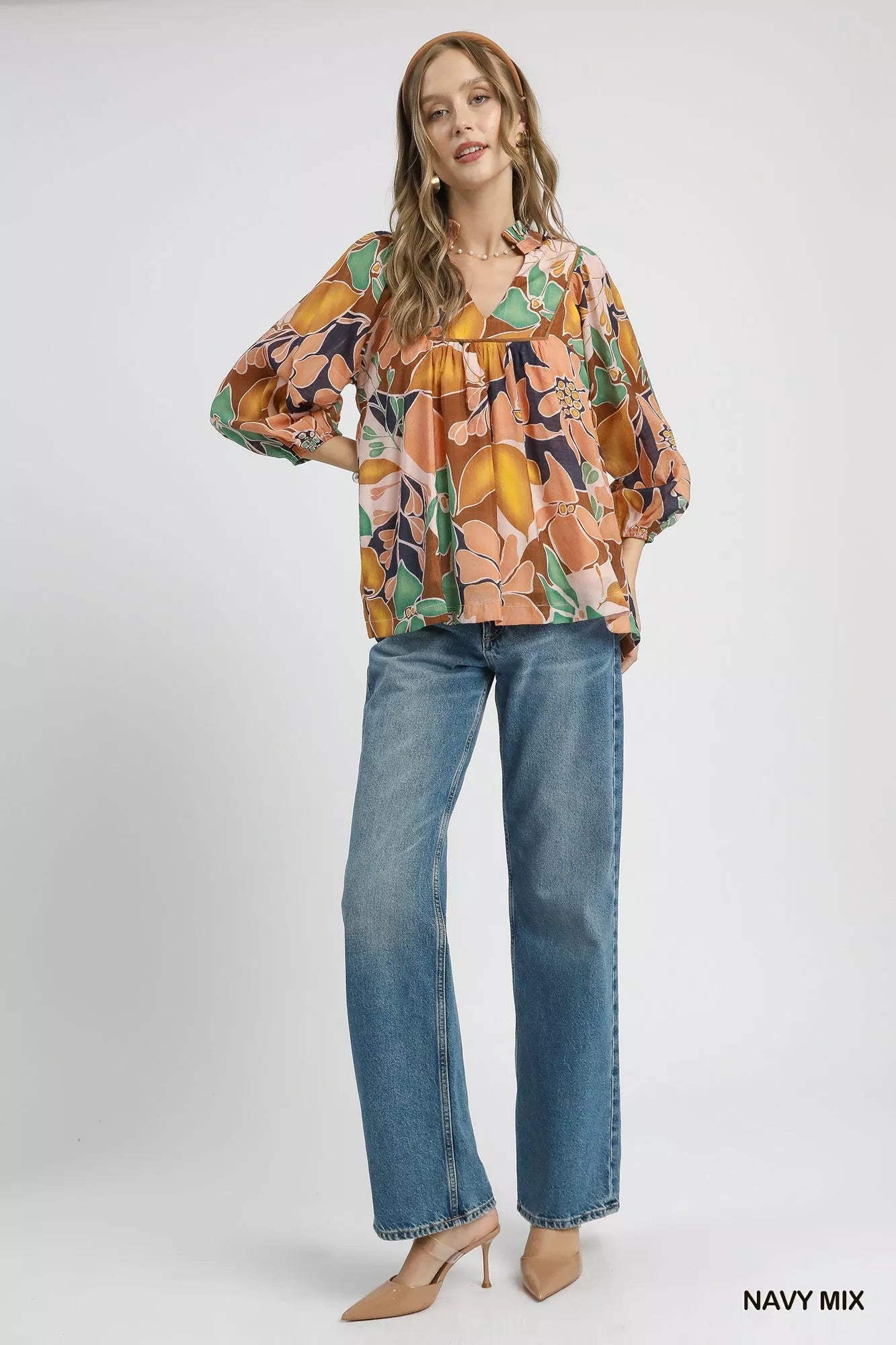 Multicolor abstract floral print blouse with ruffle neck and long sleeves.