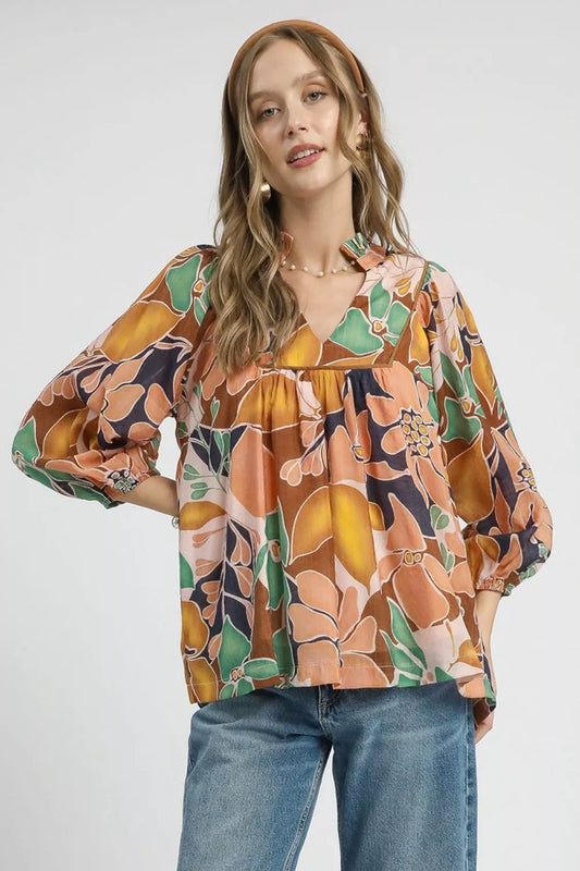 Multicolor abstract floral print blouse with ruffle neck and long sleeves.