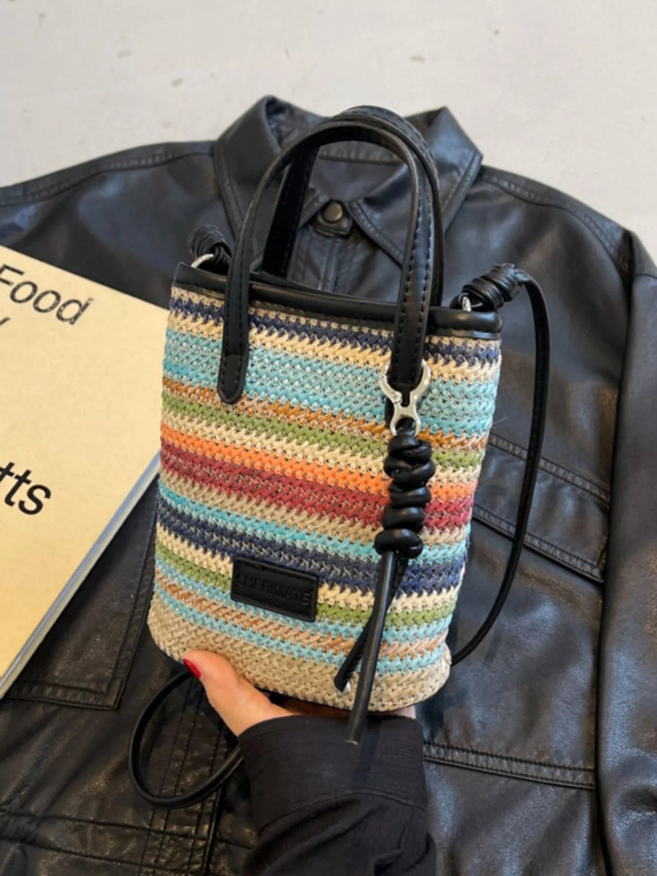 small rainbow striped woven straw mini bag with black handles and crossbody strap in a boho style