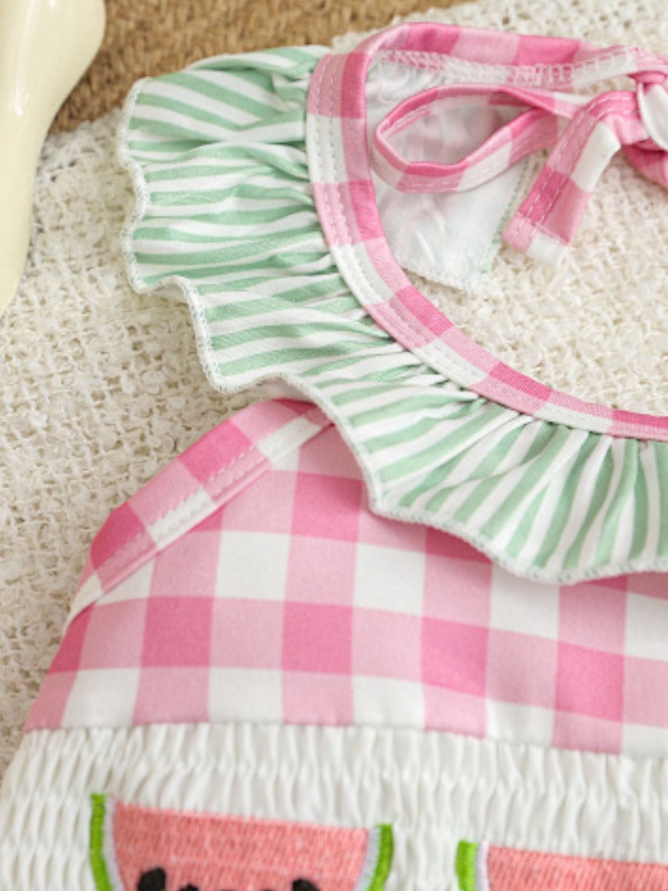 Baby romper with smocked fruit embroidery and gingham pattern