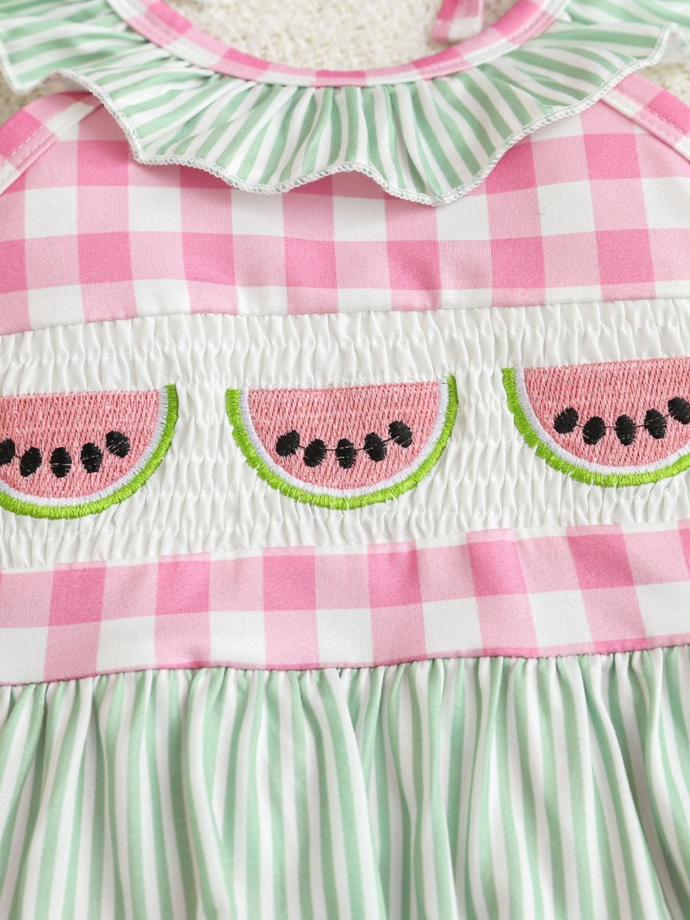 Baby romper with smocked fruit embroidery and gingham pattern