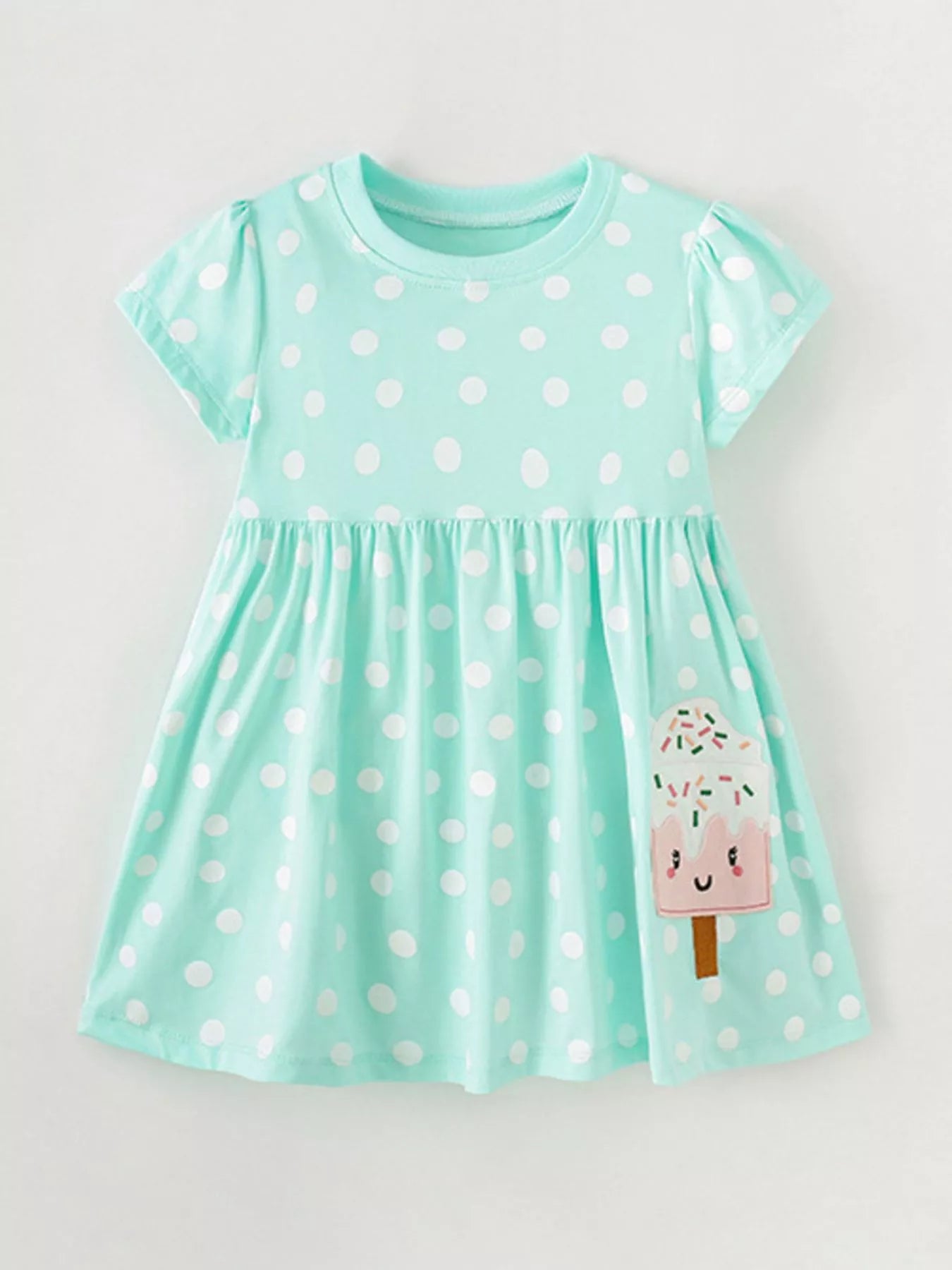 Toddler wearing mint green polka dot dress with popsicle pocket detail