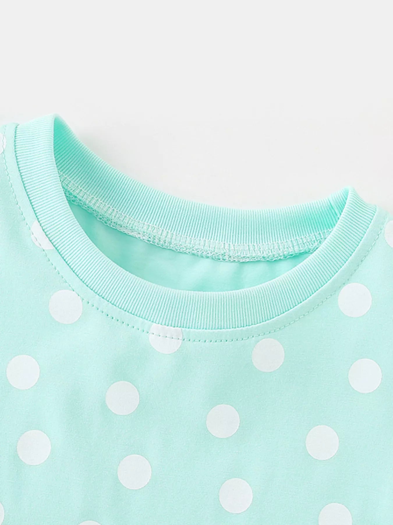 Toddler wearing mint green polka dot dress with popsicle pocket detail